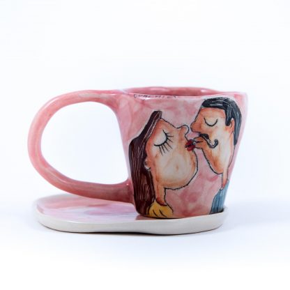 handpainted kissing couple on pink ceramic espresso cup with saucer