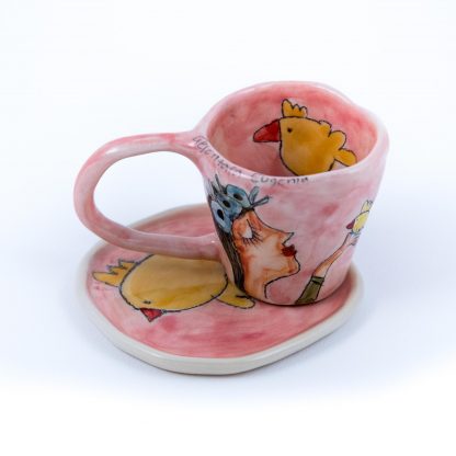 pink pottery espresso cup with handpainted portrait of a girl holding a bird